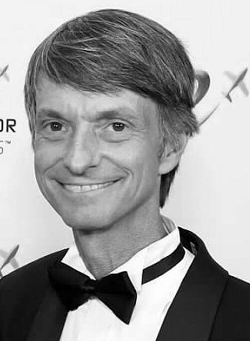 Professional black and white headshot of man in formal attire with bow tie