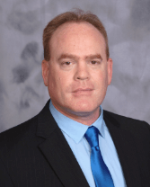 Professional headshot photo of Dan Howard in business attire with blue tie