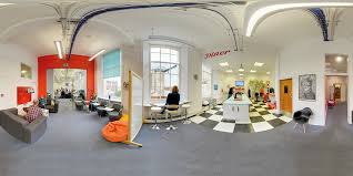 Modern coworking office space with arched windows, colorful furniture, and open collaborative layout